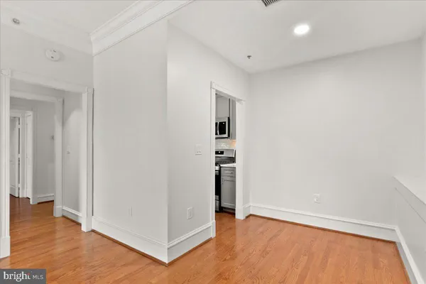 an empty room with wooden floor & windows