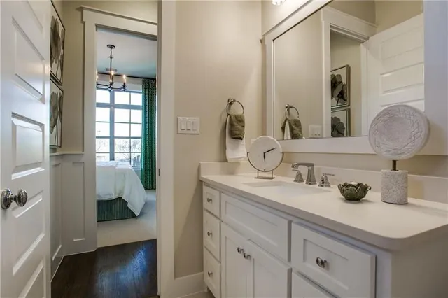 a en suite bathroom with a granite countertop sink and a mirror