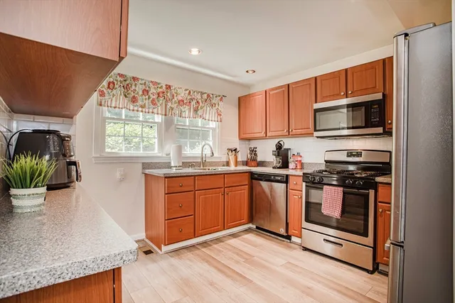 a kitchen with stainless steel appliances granite countertop a stove a sink and a microwave