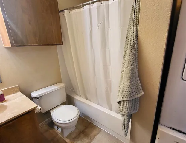 a white toilet sitting next to a shower curtain