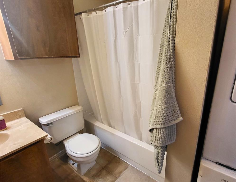 114 East 31st Street, Unit 201 Austin, TX 78705 - Photo 10 of 11 a white toilet sitting next to a shower curtain