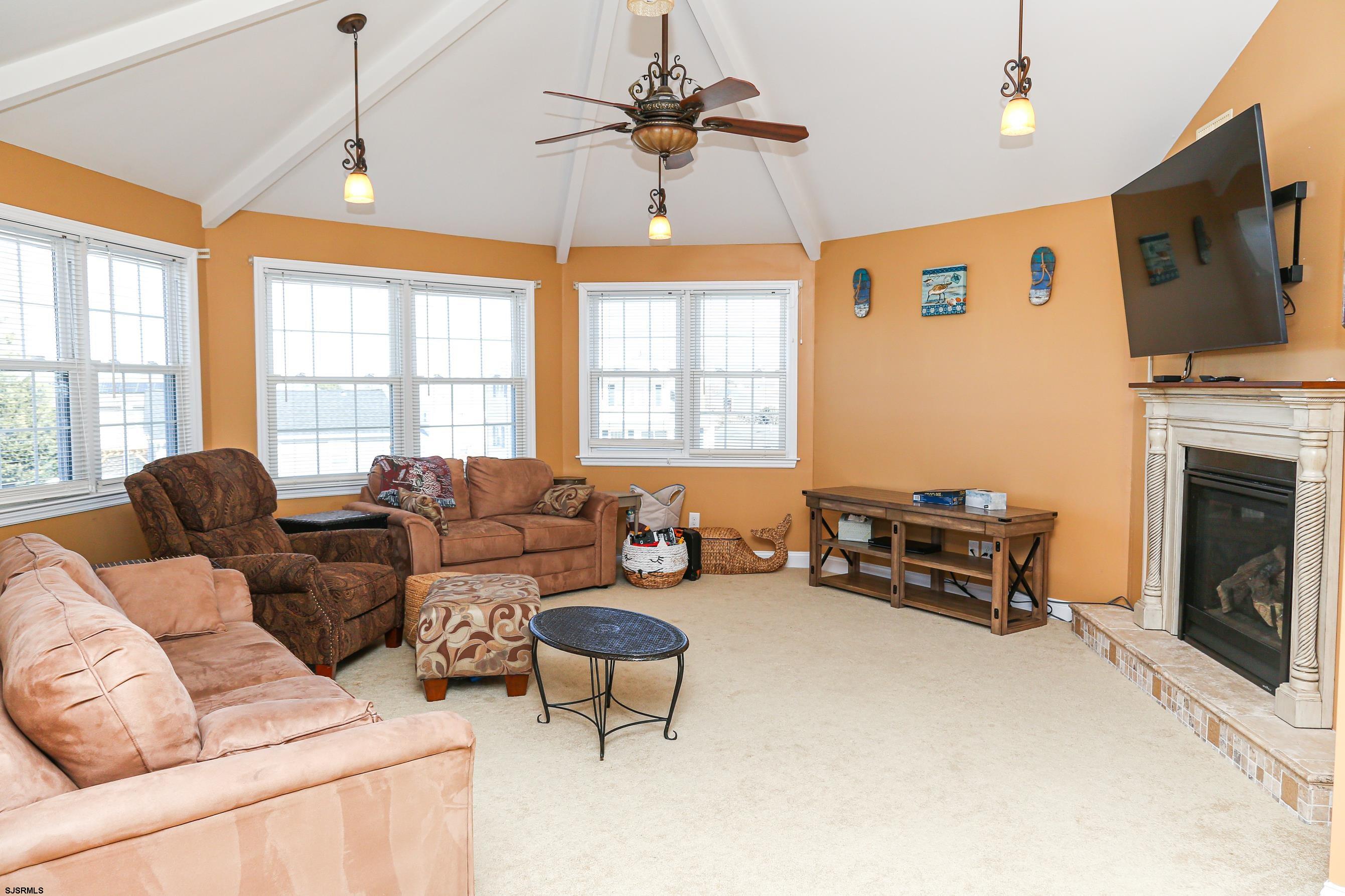 5216 Waterview Drive Brigantine, NJ 08203 - Photo 34 of 57 a living room with furniture a fireplace and a flat screen tv