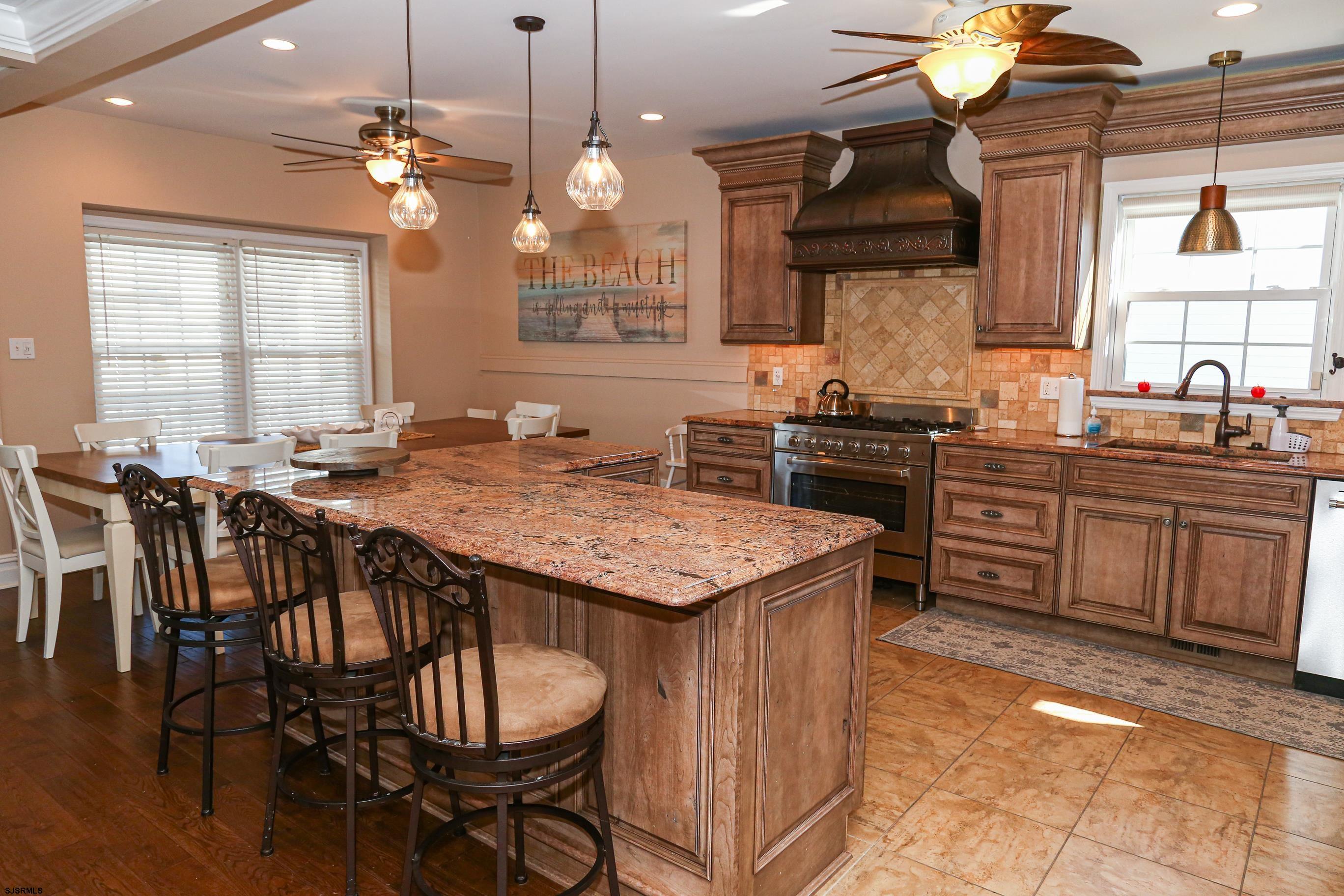 5216 Waterview Drive Brigantine, NJ 08203 - Photo 38 of 57 a kitchen with a stove a sink a dining table and chairs