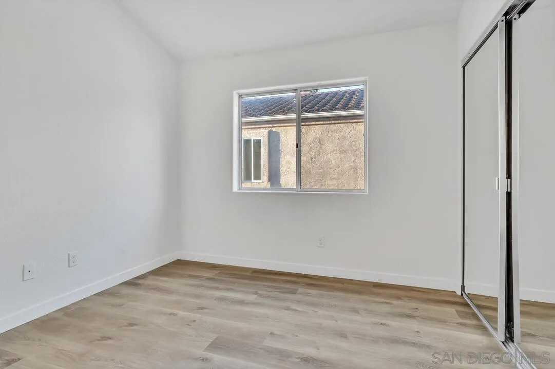 1518 Corte Roberto Oceanside, CA 92056 - Photo 32 of 41 a view of an empty room with wooden floor and a window