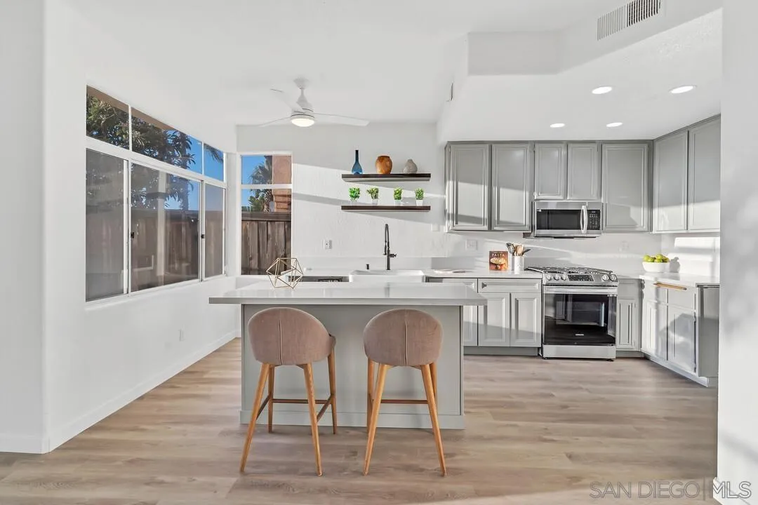 1518 Corte Roberto Oceanside, CA 92056 - Photo 7 of 41 a kitchen with stainless steel appliances granite countertop a stove top oven a sink and white cabinets