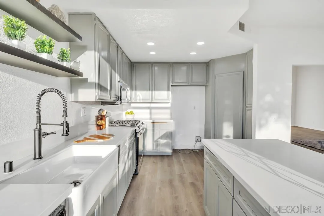 1518 Corte Roberto Oceanside, CA 92056 - Photo 9 of 41 a kitchen with kitchen island a sink stove and refrigerator