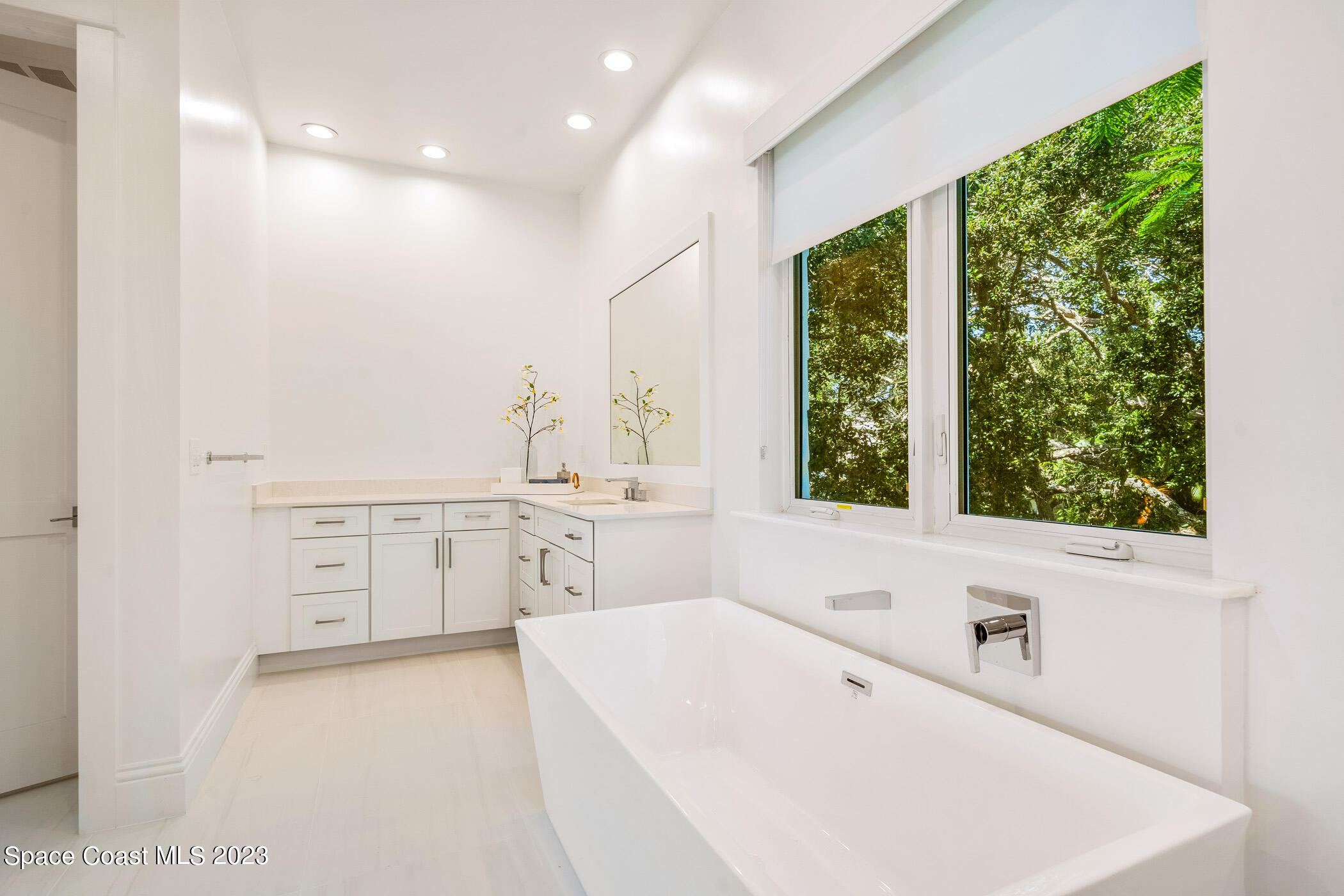 Undisclosed Address Vero Beach, FL 32963 - Photo 22 of 36 a bathroom with a bathtub a sink a vanity and a window
