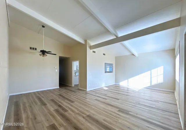 a view of an empty room with wooden floor