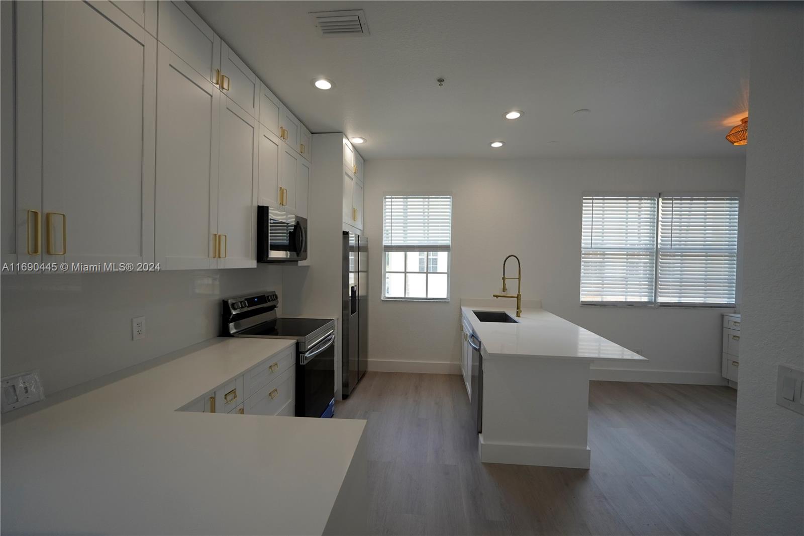 123 Harbors Way Boynton Beach, FL 33435 - Photo 15 of 38 a large white kitchen with wooden floor