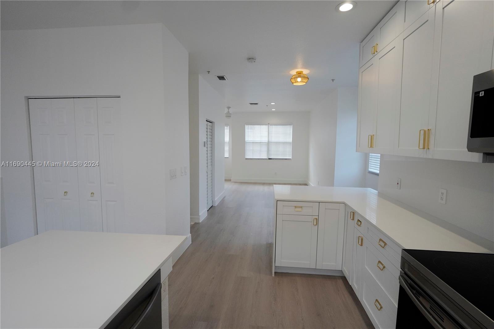 123 Harbors Way Boynton Beach, FL 33435 - Photo 17 of 38 a kitchen with a sink dishwasher and white cabinets with wooden floor