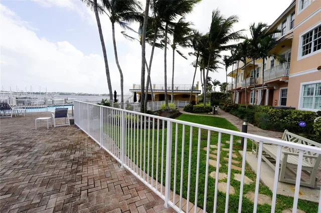 a view of a patio with table and chairs near a barbeque