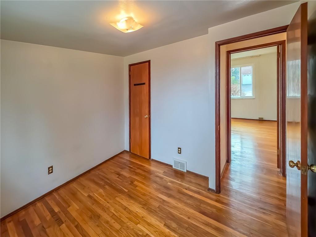 1494 Blossom Hill Road Pittsburgh, PA 15234 - Photo 18 of 40 a view of an empty room with wooden floor and a window