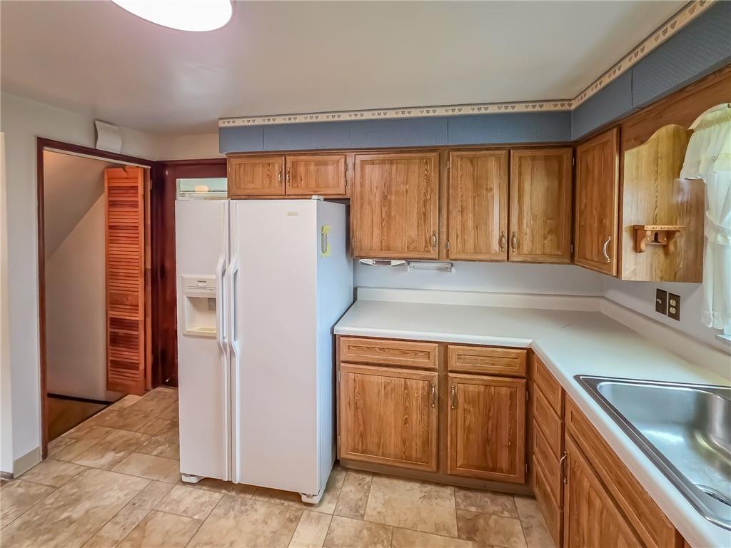 1494 Blossom Hill Road Pittsburgh, PA 15234 - Photo 23 of 40 a kitchen with a refrigerator a sink and cabinets