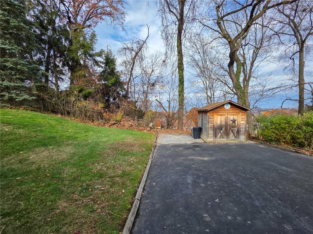 1494 Blossom Hill Road Pittsburgh, PA 15234 - Photo 37 of 40 a view of a yard with plants and a large tree