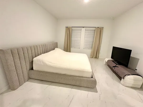 a bedroom with a bed chair and window
