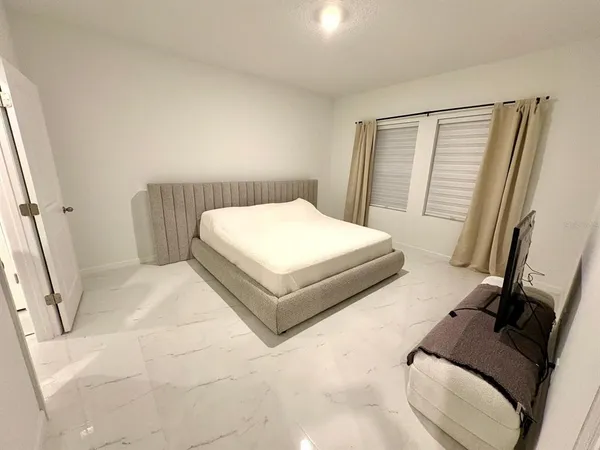 a bedroom with a bed and a flat screen tv