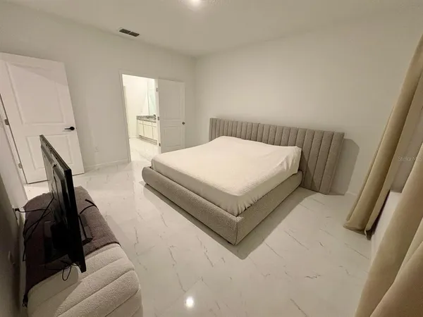 a spacious bedroom with a bed and a couch