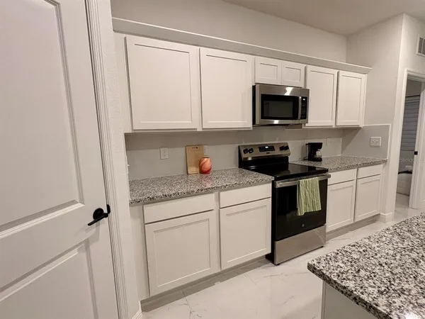 a kitchen with stainless steel appliances granite countertop a sink stove and microwave