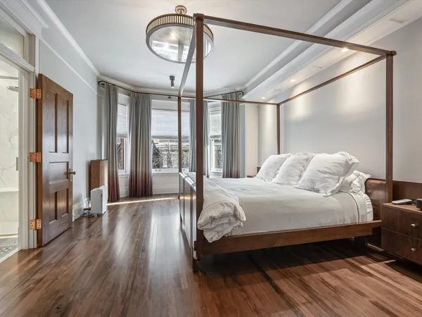 a bedroom with a bed mirror and a window