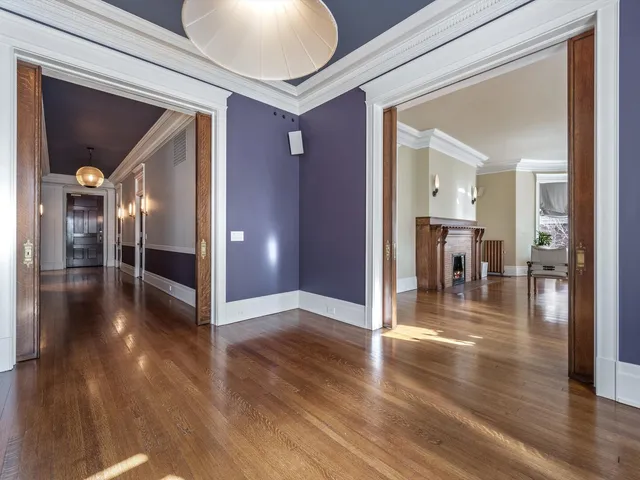 a view of a hallway view with wooden floor and dining room with wooden floor