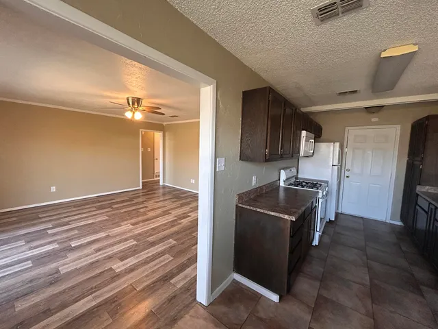 a kitchen with granite countertop a refrigerator and a stove