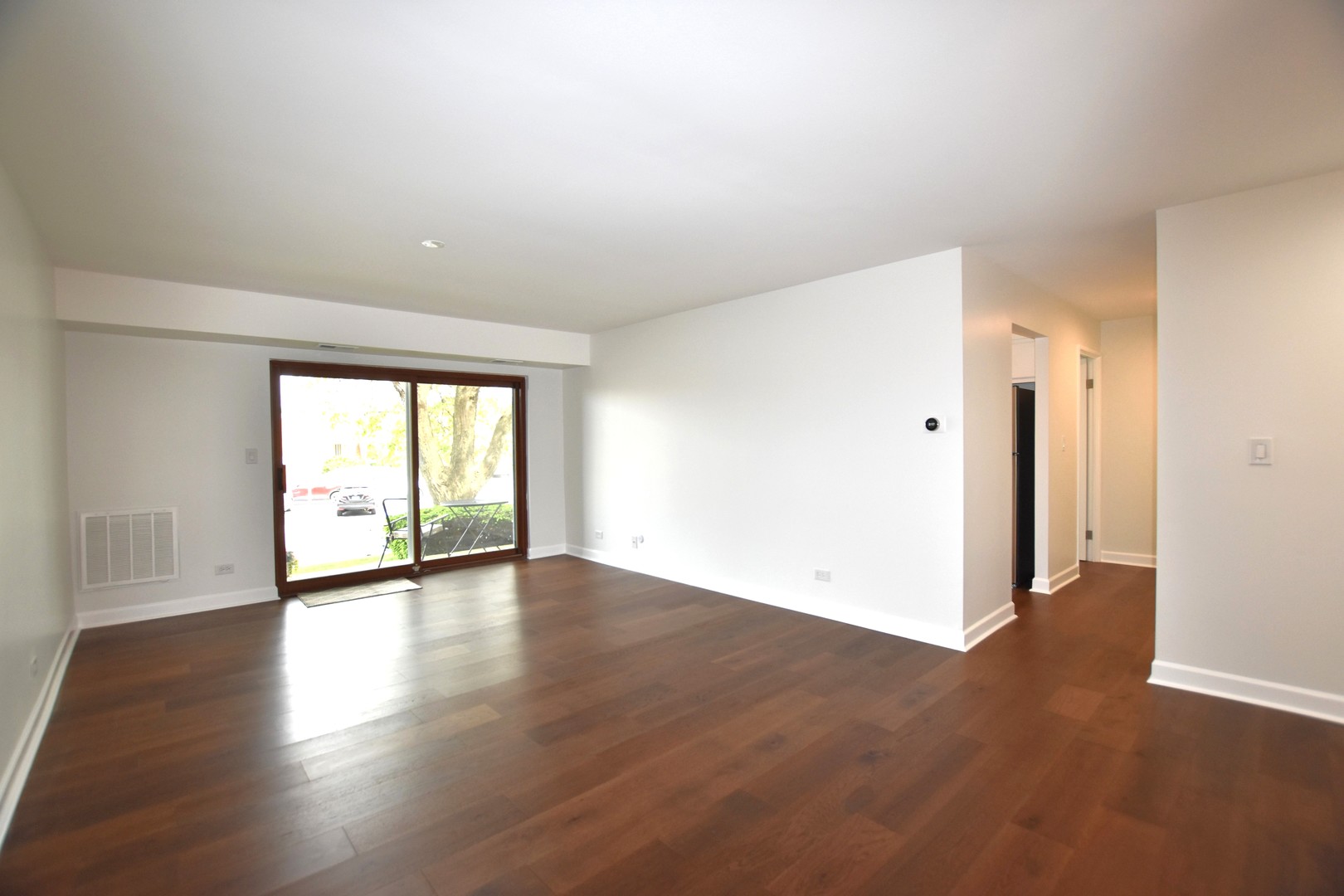 500 West Huntington Commons Road, Unit 157 Mount Prospect, IL 60056 - Photo 8 of 24 an empty room with wooden floor and windows