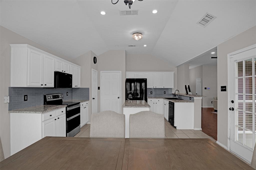 1005 Caleb Street Burleson, TX 76028 - Photo 10 of 31 a kitchen with stainless steel appliances kitchen island sink refrigerator and microwave