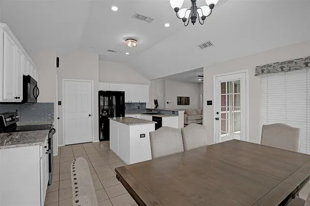 a kitchen with stainless steel appliances kitchen island sink refrigerator and microwave