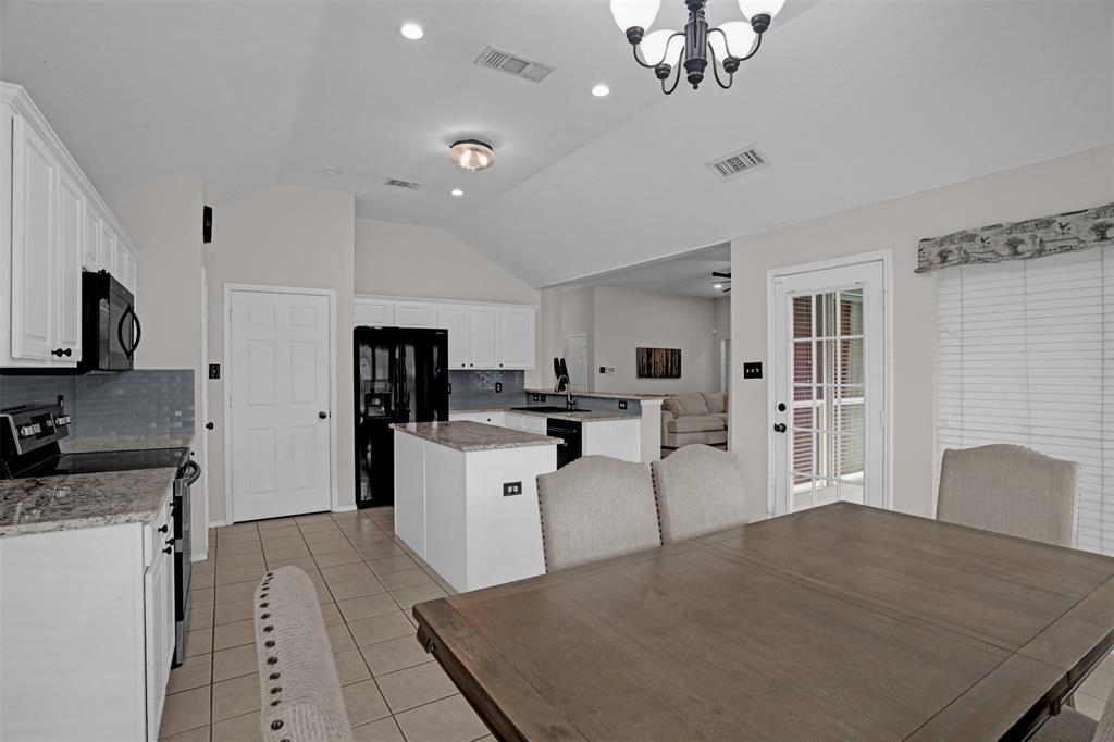 1005 Caleb Street Burleson, TX 76028 - Photo 11 of 31 a kitchen with white cabinets and stainless steel appliances