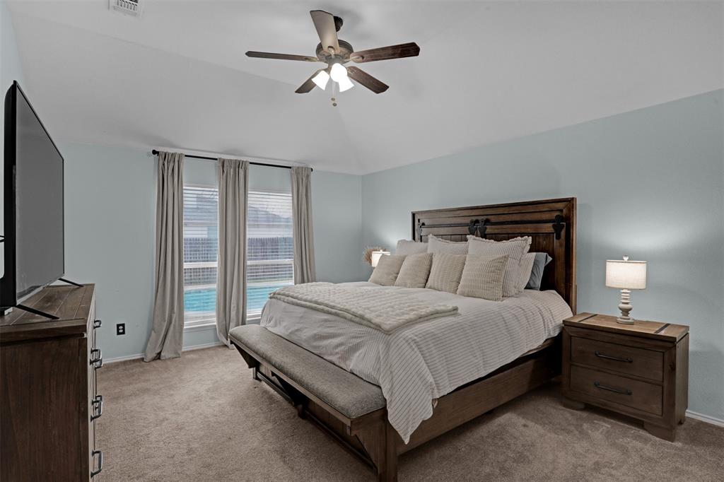 1005 Caleb Street Burleson, TX 76028 - Photo 12 of 31 a bedroom with a bed and a chandelier