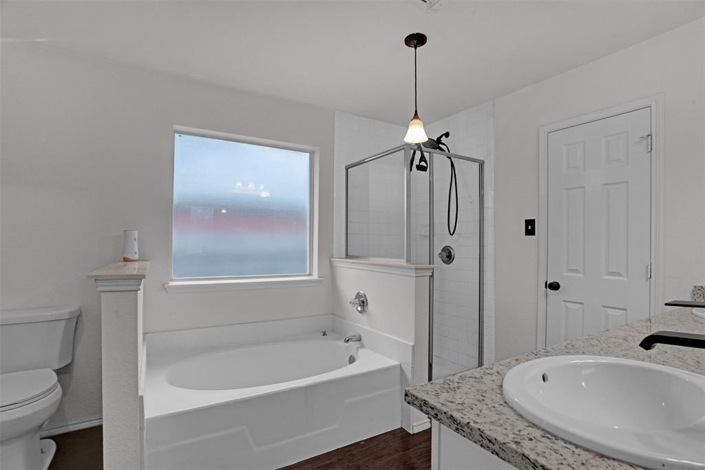 1005 Caleb Street Burleson, TX 76028 - Photo 14 of 31 a bathroom with a sink a toilet a bathtub and shower