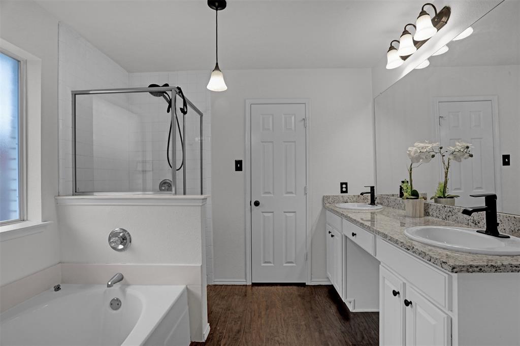 1005 Caleb Street Burleson, TX 76028 - Photo 16 of 31 a bathroom with a tub a sink and mirror