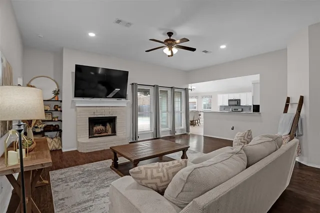 a living room with furniture a flat screen tv and a fireplace