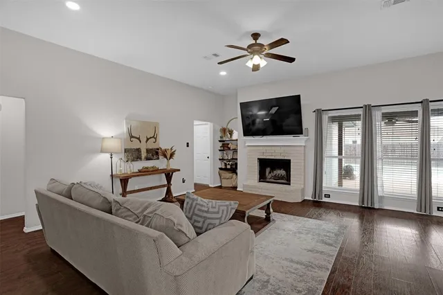 a living room with furniture a flat screen tv and a fireplace