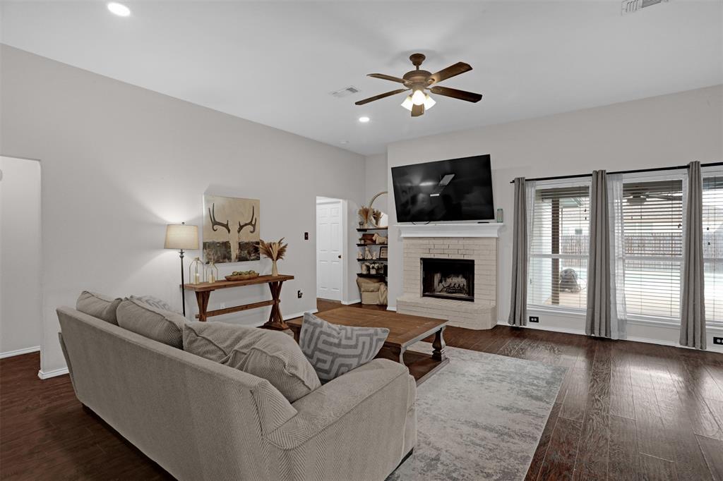 1005 Caleb Street Burleson, TX 76028 - Photo 5 of 31 a living room with furniture a flat screen tv and a fireplace