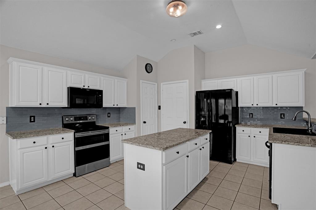 1005 Caleb Street Burleson, TX 76028 - Photo 8 of 31 a kitchen with granite countertop a sink stove and refrigerator