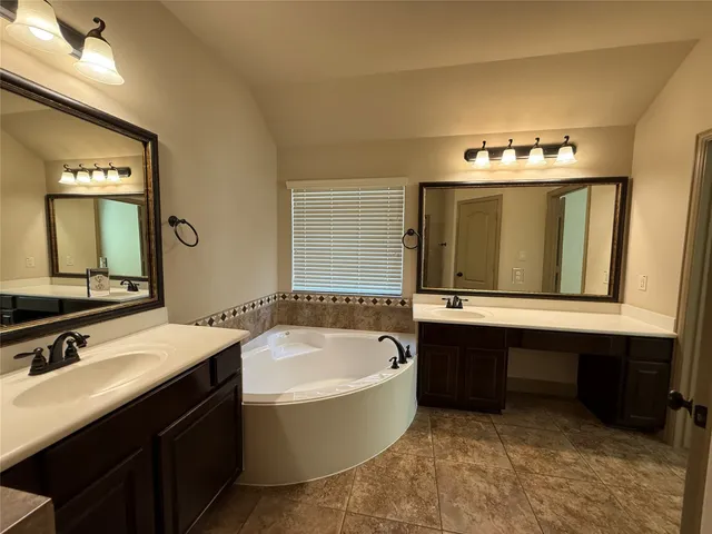 a bathroom with a tub sink and mirror