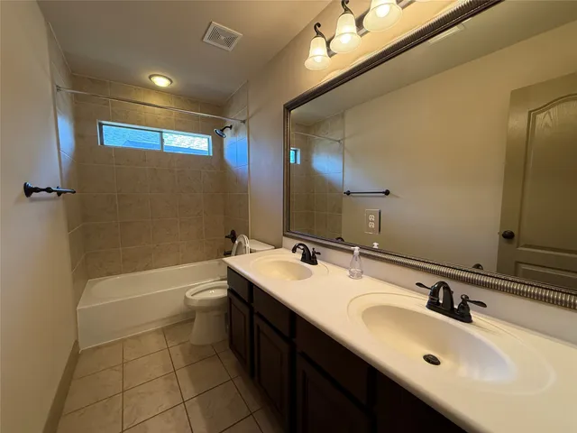 a bathroom with a sink double vanity granite tub and a mirror
