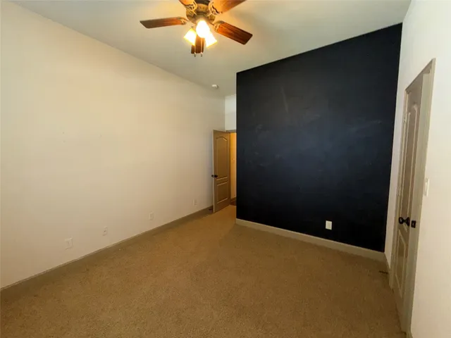 an empty room with a chandelier fan