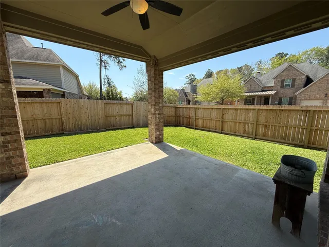 an empty room with a window and a ceiling fan