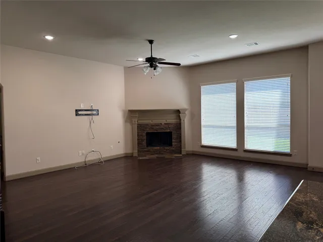 an empty room with windows fireplace and a sink