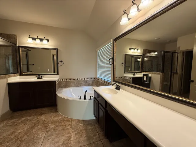 a bathroom with a tub sink and mirror