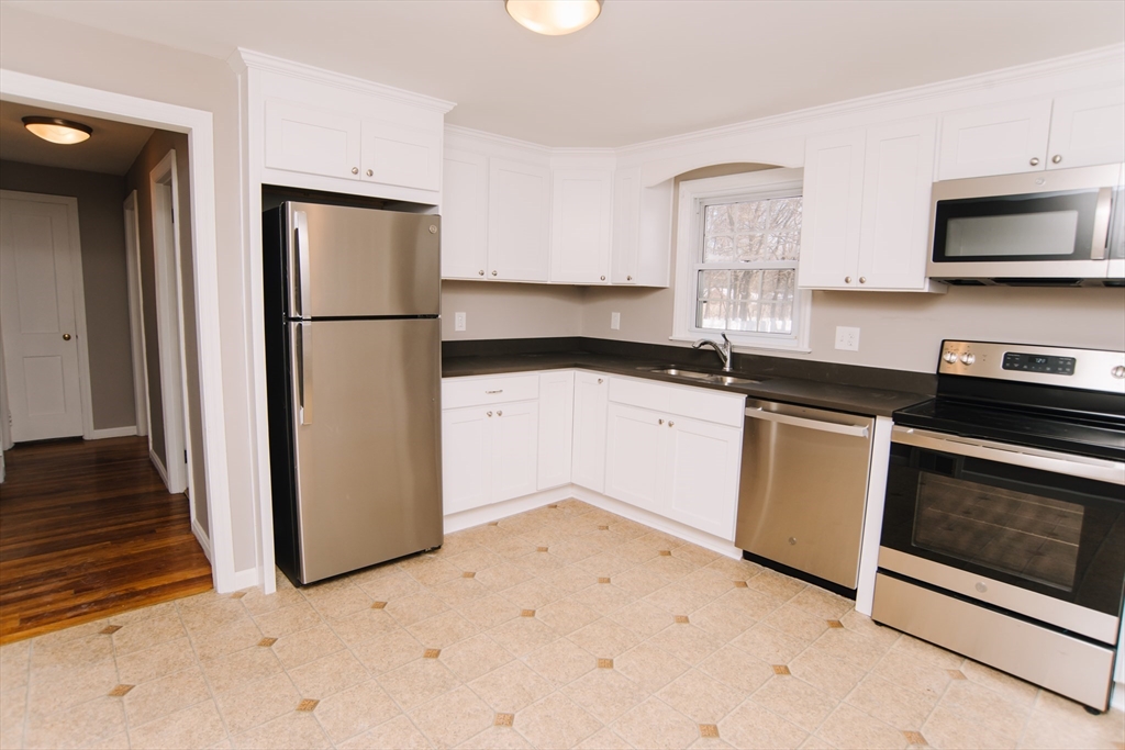 75 Lumae Street Springfield, MA 01119 - Photo 14 of 38 a kitchen with granite countertop white cabinets and stainless steel appliances