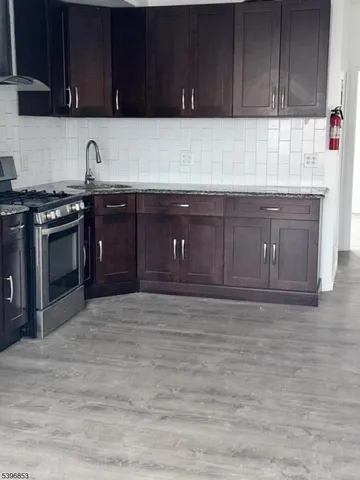 a kitchen with granite countertop wood cabinets and stainless steel appliances