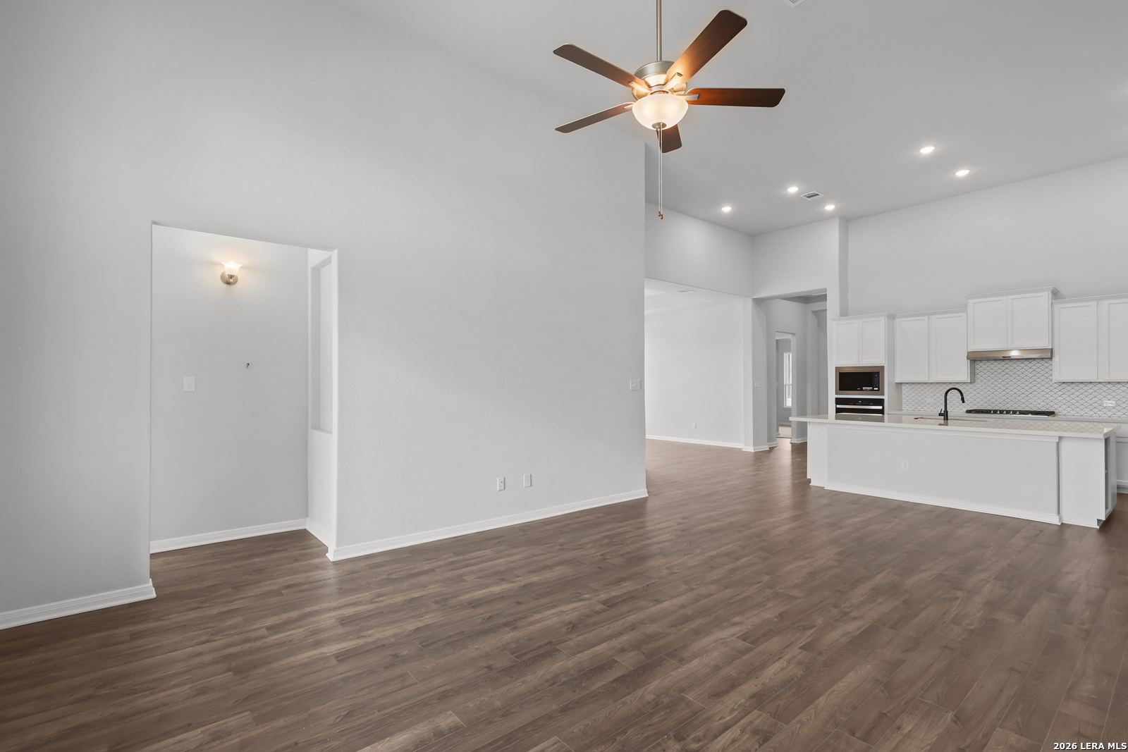 220 Fillmore Falls Cibolo, TX 78108 - Photo 12 of 30 a view of an empty room and kitchen with wooden floor