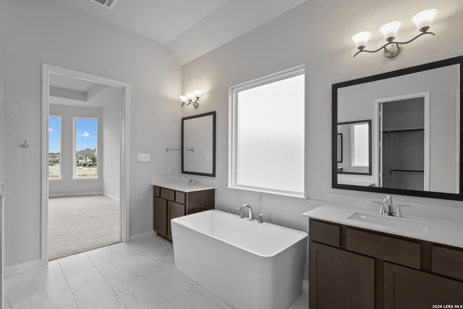 220 Fillmore Falls Cibolo, TX 78108 - Photo 17 of 30 a bathroom with a double vanity sink a tub and a mirror
