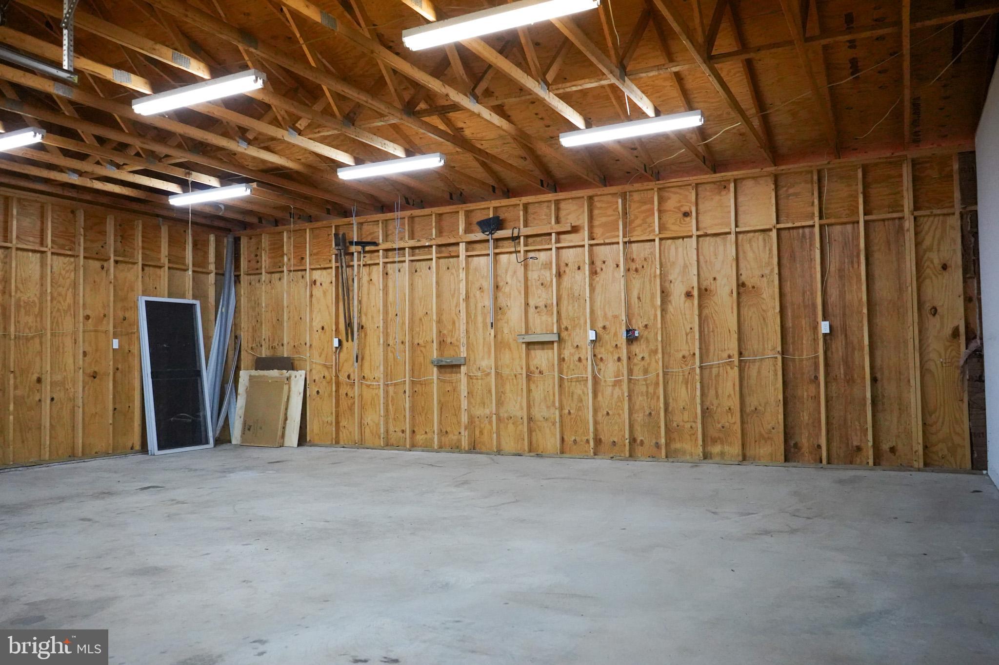 7323 O'Keefe Road Bealeton, VA 22712 - Photo 41 of 48 Spacious garage with wooden walls and lights.