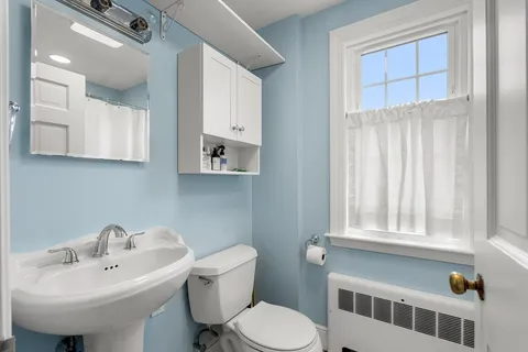 a bathroom with a sink toilet and mirror