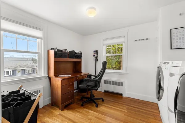 a view of a workspace with furniture and a window