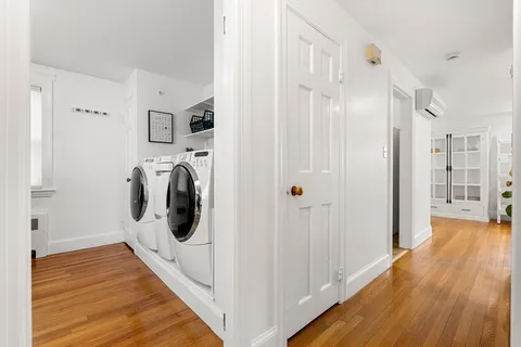 a view of a hallway with wooden floor and closet